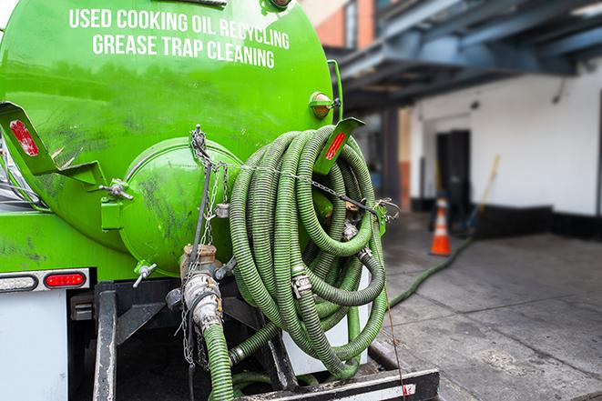 a technician pumping a grease trap in a commercial building in Louisville OH